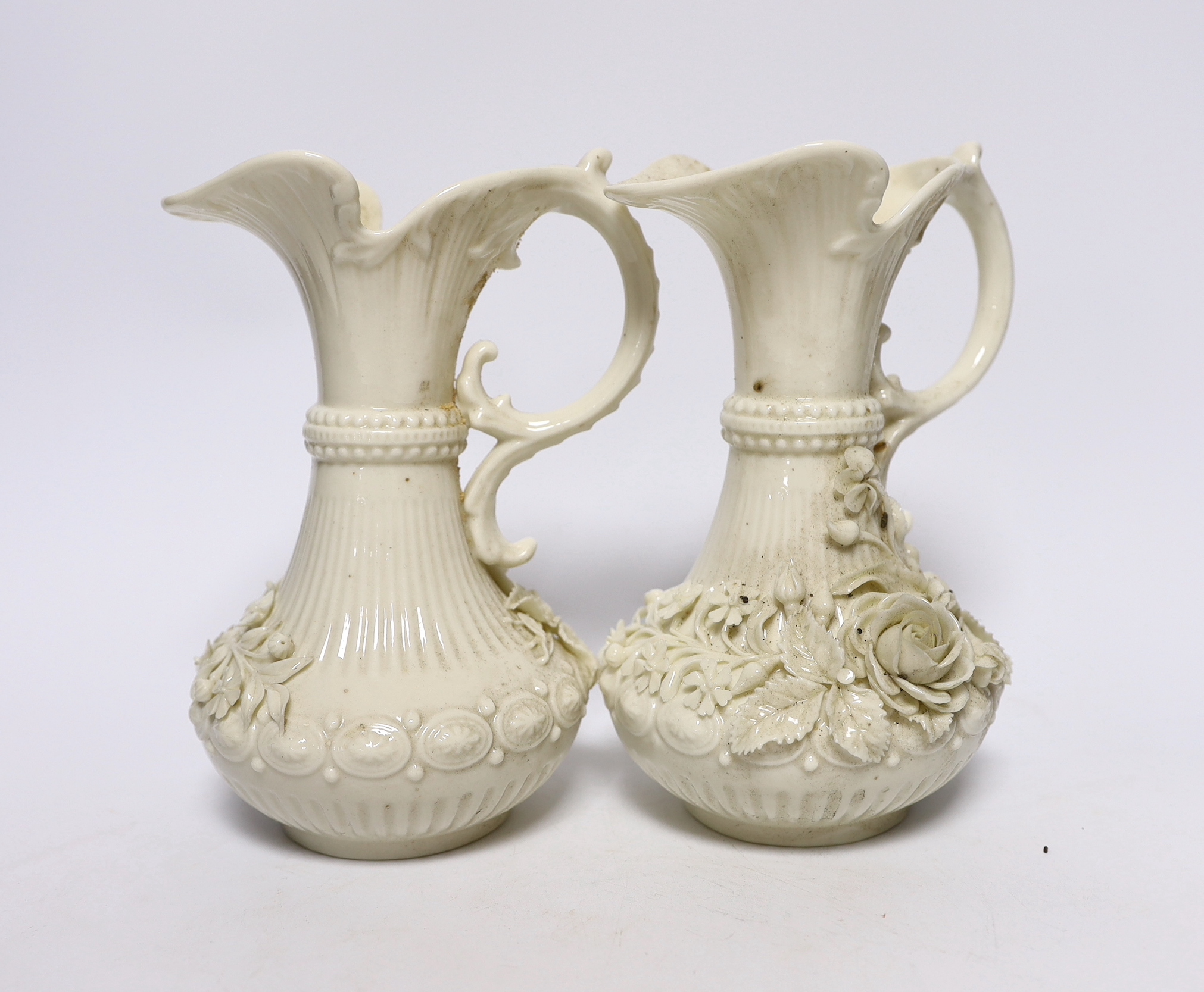 A pair of Belleek jugs with applied rose decoration, 19 cm high